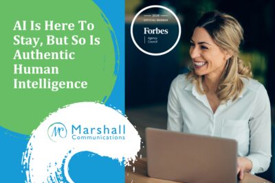 AI Is Here To Stay, But So Is Authentic Human Intelligence - Woman at laptop looking away and smiling