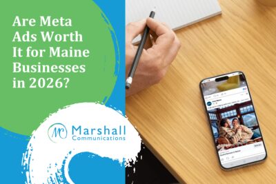 Are Meta Ads Worth It for Maine Businesses in 2026? - Person holding a pencil over a pad of paper in the top left corner and a phone with a Facebook ad in the bottom right corner